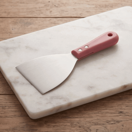 Wide stainless steel knife and cutter for harissa and basbousa with a comfortable, secure handle.